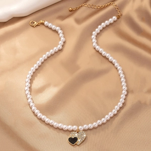 Collier de perles élégant avec pendentif double cœur sur tissu de soie champagne luxueux