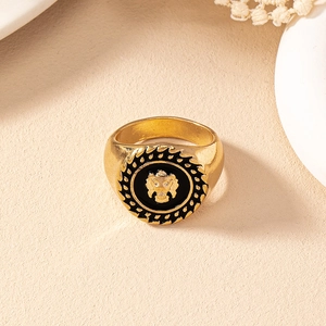 Detail of a vintage golden lion head signet ring with black enamel and serrated edges