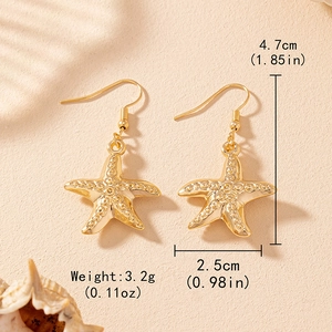 Golden starfish drop earrings with textured relief and ocean-inspired vacation style