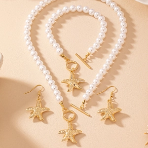Detailed view of pearl jewelry set featuring gold starfish charms and OT toggle clasps