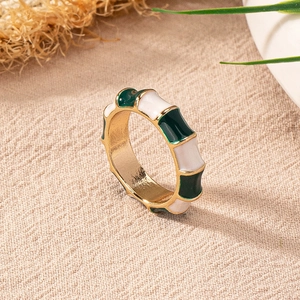 Detailed view of a gold-plated ring with forest green and ivory enamel inlays