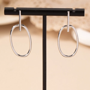 Minimalist silver geometric oval hollow earrings hanging on a black T-shaped stand