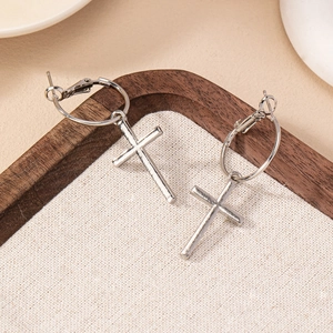 Créoles croix minimalistes en argent sur plateau bois pour un style quotidien