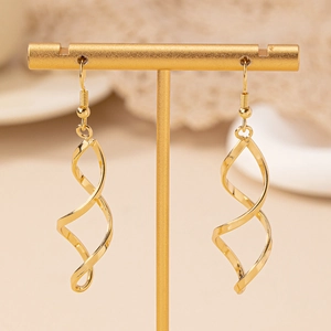 Boucles d'oreilles spirales dorées présentées sur un support en T sur fond beige doux