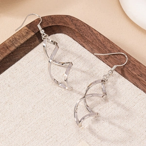 Boucles d'oreilles spirales argentées minimalistes sur lin avec finition polie