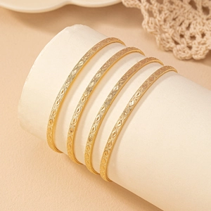 Five-piece set of gold minimalist bangles with geometric diamond texture for women