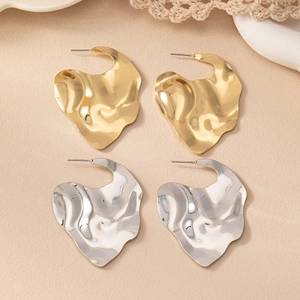 Vue détaillée des boucles d'oreilles cœur irrégulières en or et argent avec texture martelée