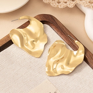 Boucles d'oreilles dorées irrégulières au design moderne avec texture de métal poli