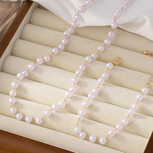 Élégant collier de perles blanches avec chaîne dorée dans un coffret cadeau en velours