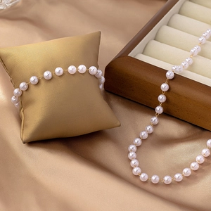 Ensemble collier et bracelet en perles élégantes avec chaîne dorée sur satin doré