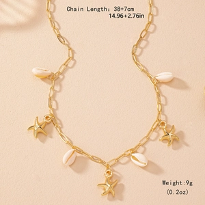 Gold starfish and shell necklace with rectangular link chain on a beach sand background