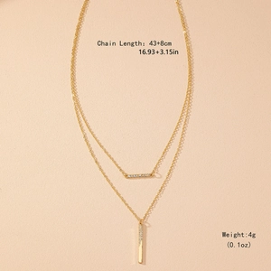 Collier double rang doré avec barres géométriques serties de zircons sur fond abricot