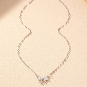 Détail du pendentif papillon argenté avec finition lisse et polie sur chaîne fine