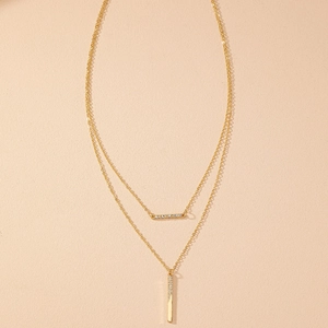 Détail du collier double couche doré avec pendentifs barres ornés de strass