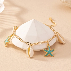 Close-up of gold starfish and seashell charms on an elegant ocean-themed bracelet