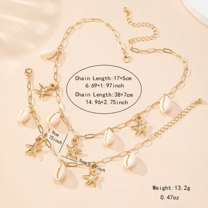 Parure de bijoux dorés avec collier et bracelet étoile de mer et coquillages sur sable