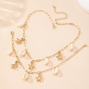 Détails des breloques d'étoiles de mer et coquillages sur collier de plage doré