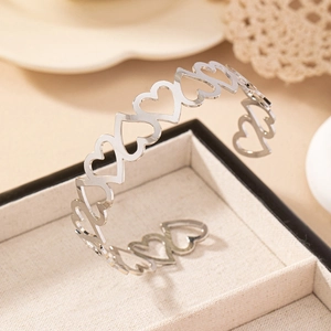 Bracelet manchette argenté ajouré en forme de cœur sur une boîte à bijoux en velours