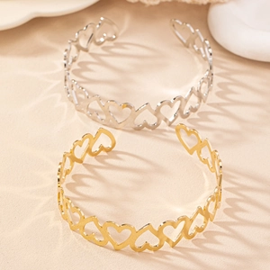 Détail des bracelets ajourés en forme de cœur dorés et argentés avec ombres élégantes