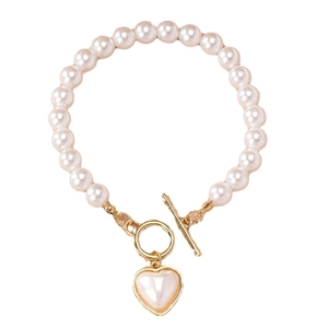 Bracelet élégant en perles avec pendentif cœur et fermoir à bascule doré sur fond blanc