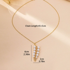 Elegant gold leaf pendant necklace with white imitation pearls on a neutral background