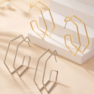 Detailed view of large geometric hexagonal hoop earrings in polished gold and silver finish