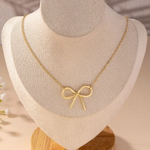 Minimalist gold bow necklace on O-chain displayed on a professional jewelry bust stand