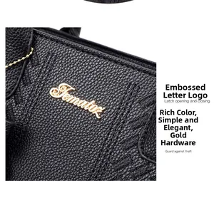 Vue macro d'un sac en cuir noir grainé avec logo métallique Tomato doré et détails dorés