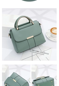 Détails d'un sac à main vert mat avec poignées en métal doré et rivets de protection