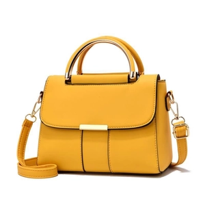 Détail du sac à main en cuir jaune vif avec fermoir en métal doré et texture litchi