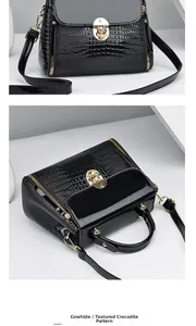 Detail of black lizard-textured cowhide handbag with gold lock and polished finish
