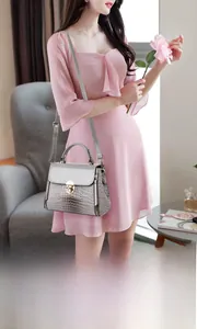 Detailed texture of grey lizard pattern crossbody bag with golden metal buckle clasp