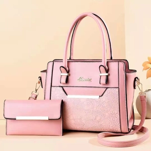Detail of pink faux leather tote bag set with floral embossing and matching wallet