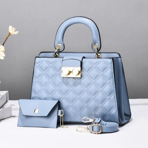 Detail view of light blue quilted tote bag set with golden hardware and accessories