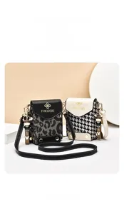Detail of leopard and houndstooth mini crossbody bags with gold logo and cute charms