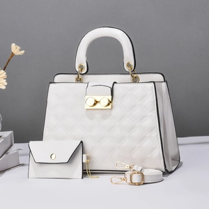 Detail of white diamond quilted handbag with golden twist lock and adjustable strap