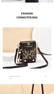 Detail of leopard print crossbody bag with brown leather trim and cute monkey charm accessory