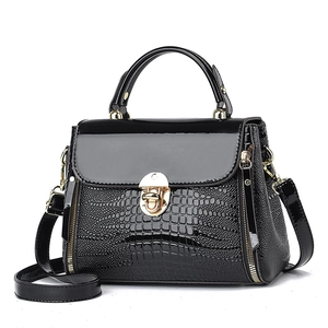 Elegant black lizard pattern crossbody handbag with golden clasp on white background