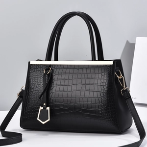 Black crocodile embossed tote bag with gold hardware and adjustable crossbody strap