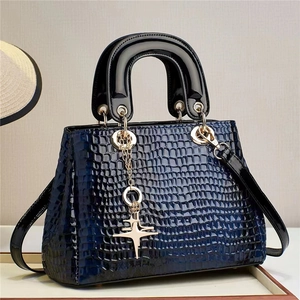 Glossy navy crocodile embossed handbag with gold star charm and black top handles