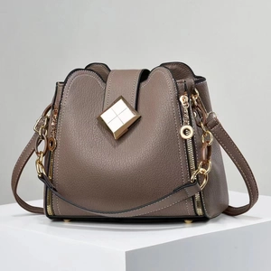 Détails du sac seau en cuir grainé avec ferrures dorées et surpiqûres blanches