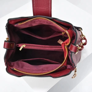 Détails de l'intérieur du sac seau bordeaux montrant les compartiments et fermetures dorées