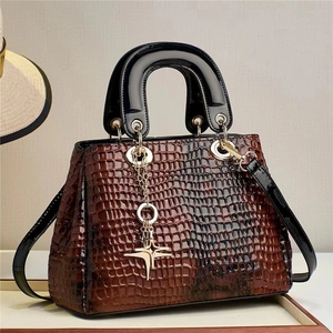 Brown crocodile pattern tote bag with black glossy handles and gold star pendant