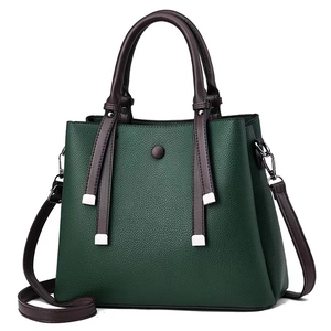 Detail of dark green pebbled leather handbag with brown handles and silver hardware