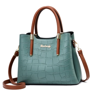 Detail of crocodile pattern leather bag with golden Danbaoly logo and brown handle