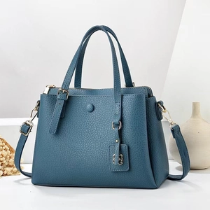 Minimalist grey-blue lychee grain crossbody bag with top handle and gold hardware detail
