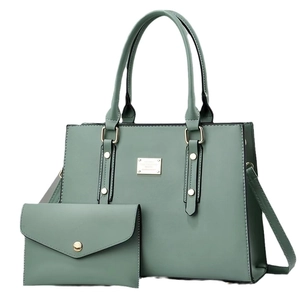 Sage green tote bag and envelope clutch set with gold hardware on white background