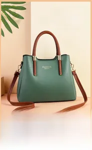 Detail view of retro dark green handbag with brown handles and gold logo lettering