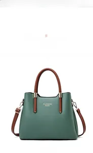 Front view detail of dark green leather tote bag with gold Fashion Queen logo
