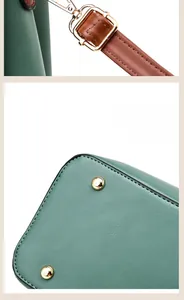 Close-up of green crocodile leather bag with gold studs and adjustable strap